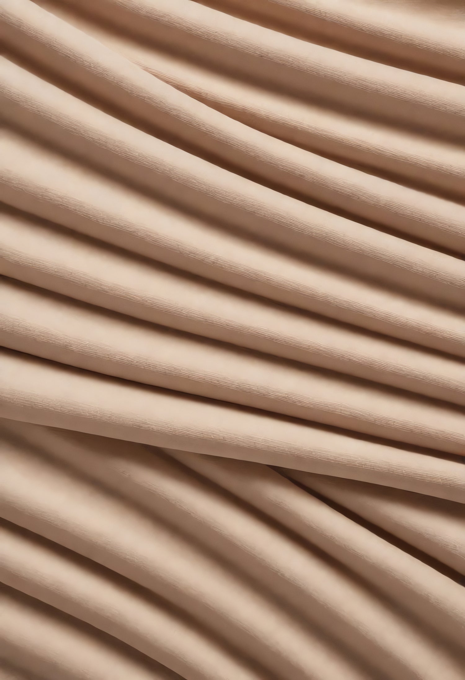 Soft, textured fabric draping elegantly against a neutral background in warm, muted tones