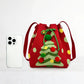 Red drawstring bag with Christmas tree design next to a smartphone on a white background