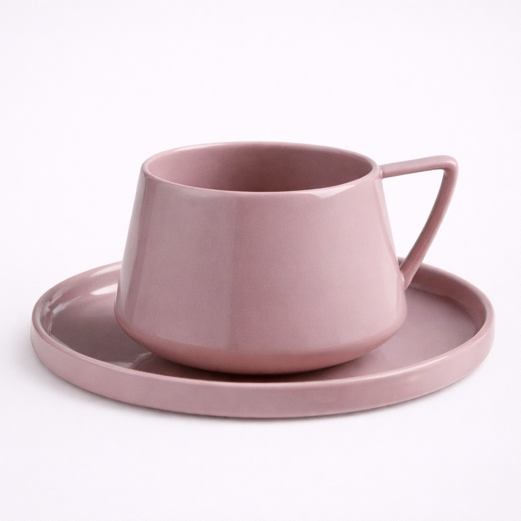 Pink ceramic cup and saucer set on a white background