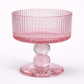 Pink glass pedestal bowl on a white background