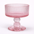 Pink glass pedestal bowl on a white background