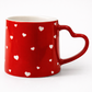 Red mug with white heart patterns on a white background