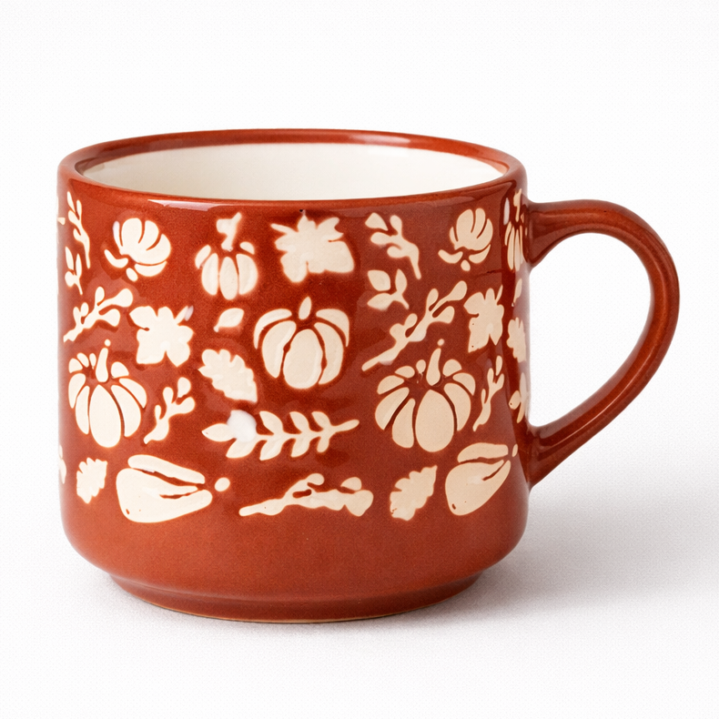 Red ceramic mug with white floral patterns on a white background
