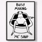 Framed black and white illustration of a person sitting in a chair with text 'BUSY MAKING ME SOUP' on a light gray background.