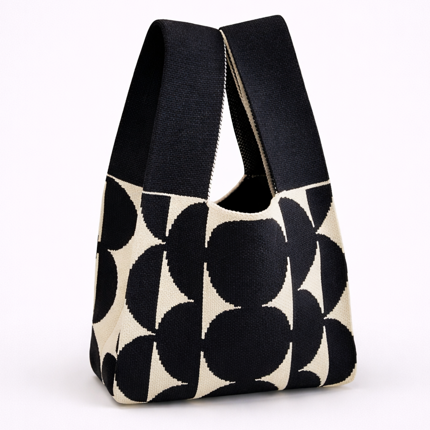 Black and white patterned bag with black handles on a white background