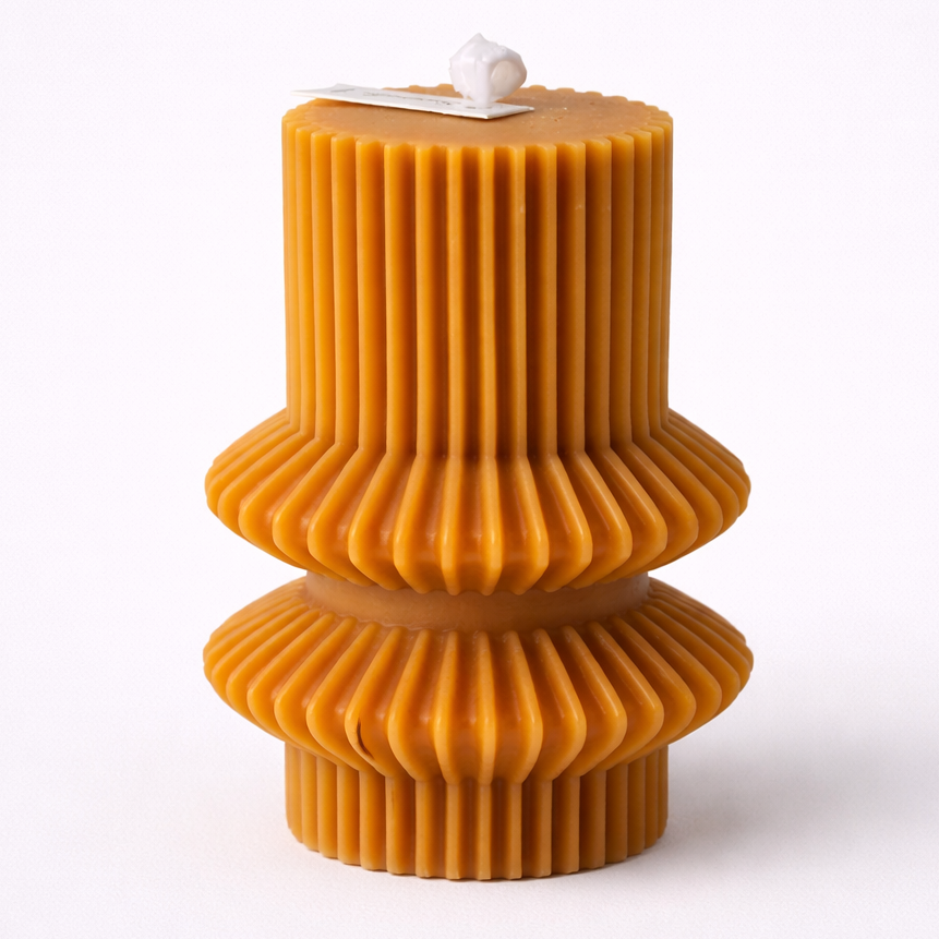 Beeswax candle with ribbed design on a white background