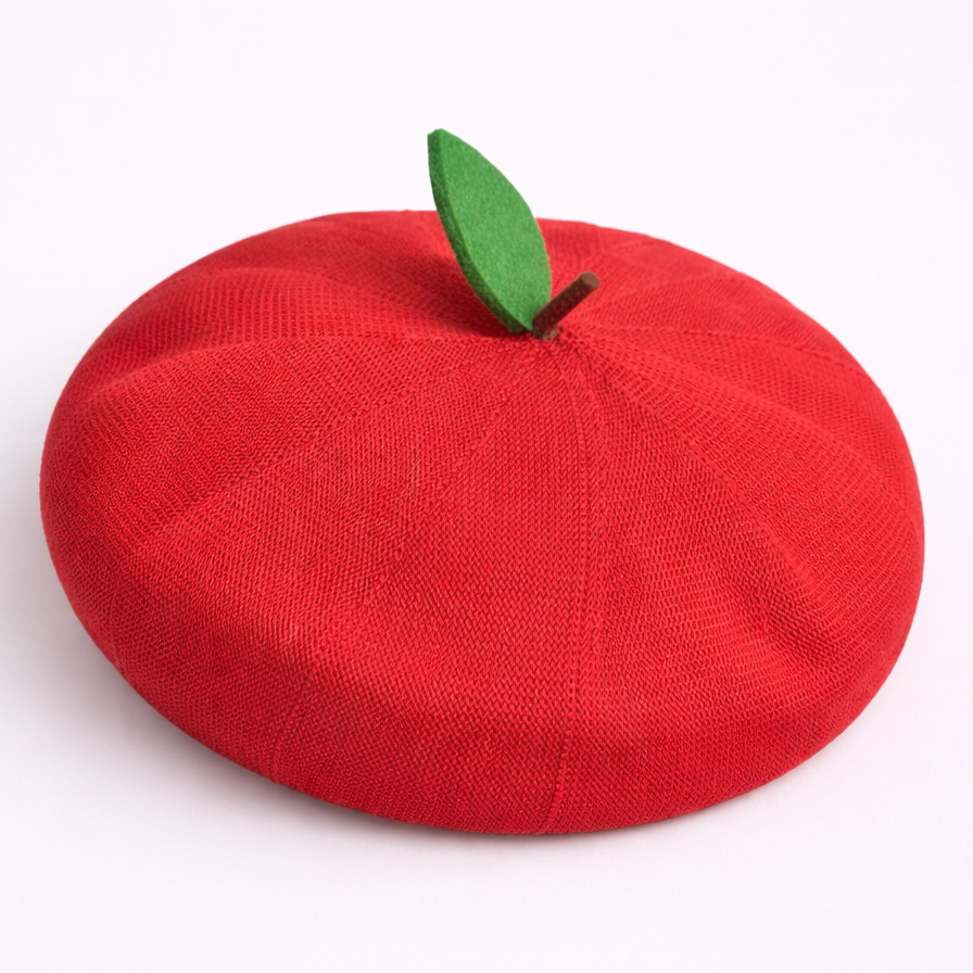 Red beret shaped like an apple with a green leaf on a white background