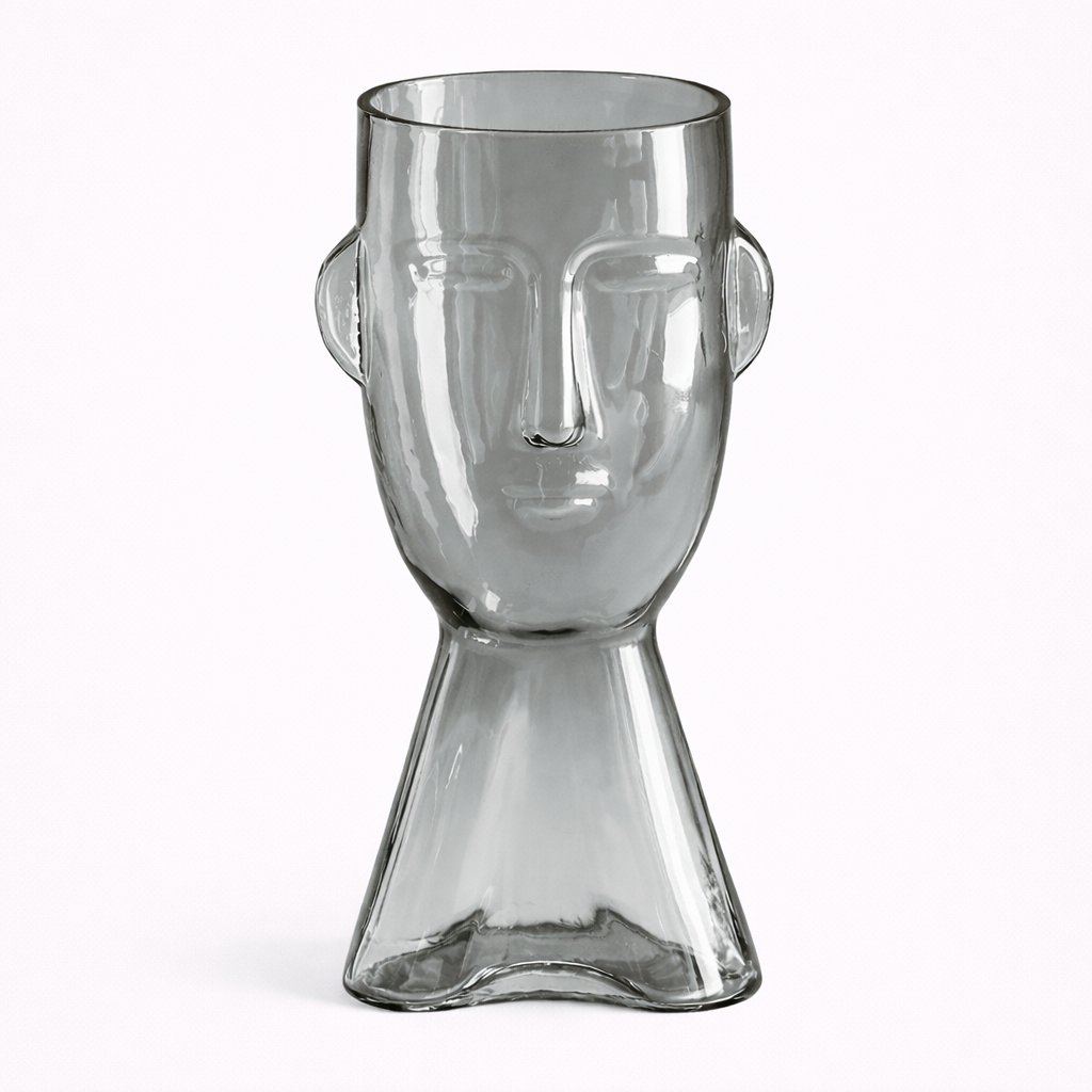 Clear glass vase shaped like a face on a white background
