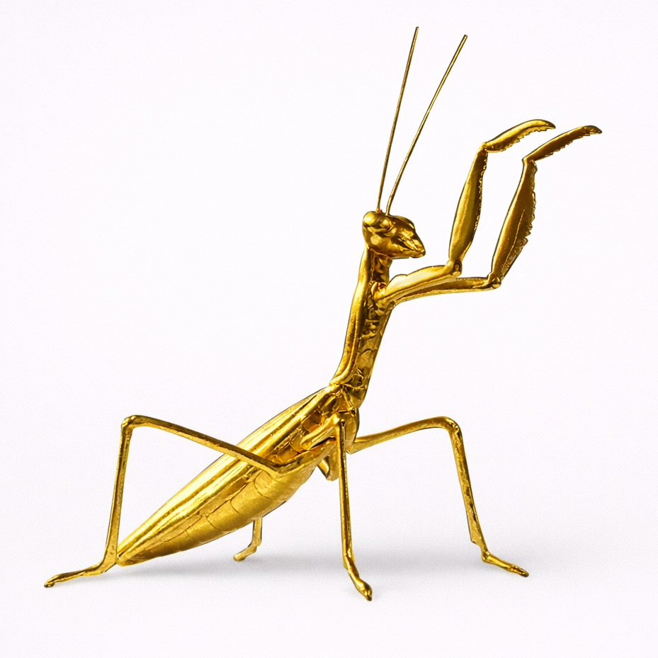 Gold praying mantis figurine on a white background