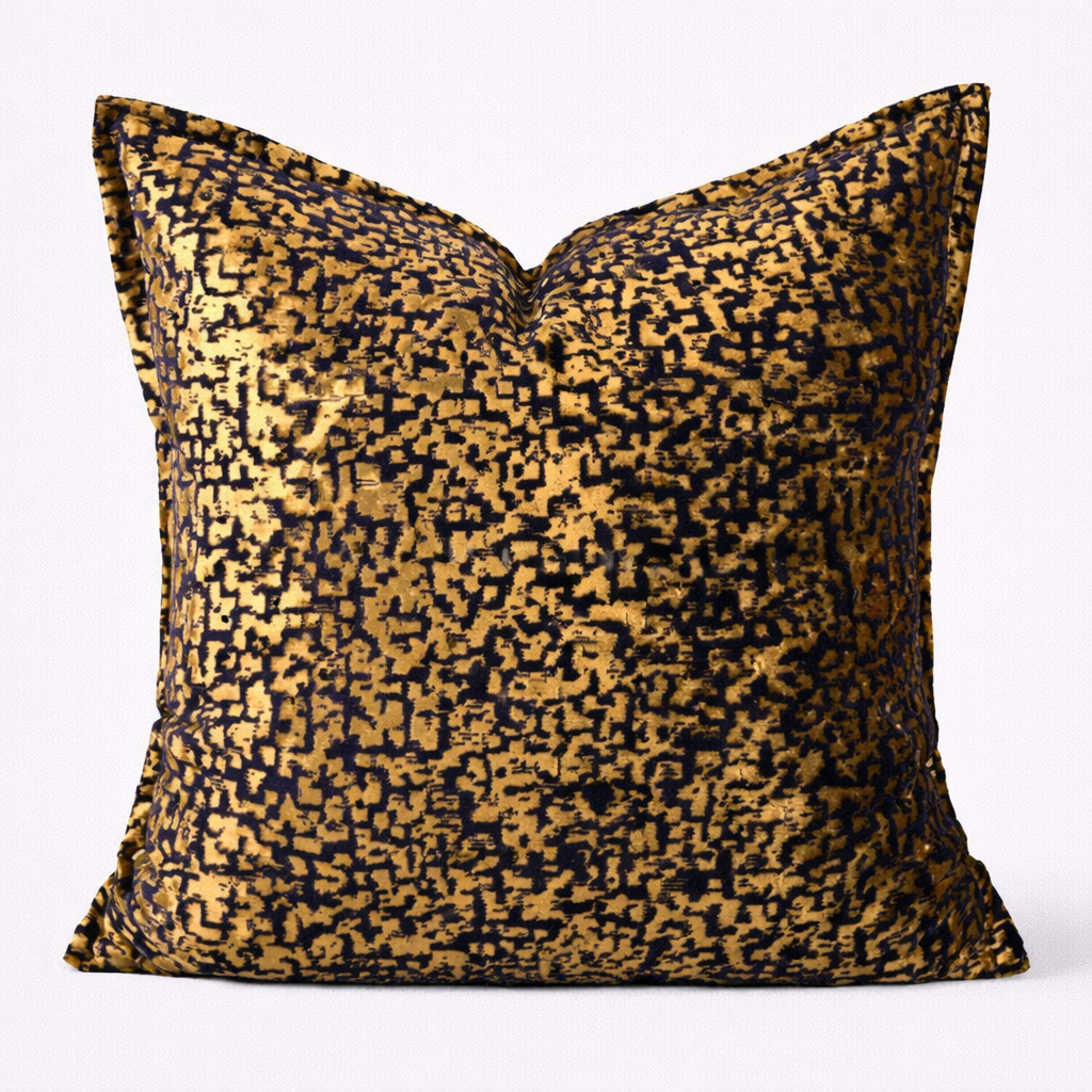 Decorative pillow with gold and black pattern on a white background