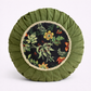 One round floral-patterned cushion on a white background