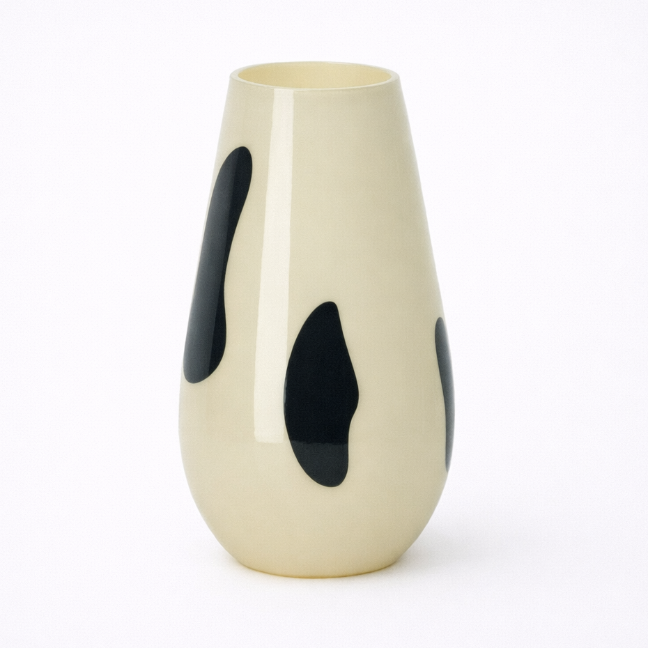 Beige vase with black spots on a white background