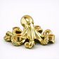Gold octopus candle holder with measurements on a white surface