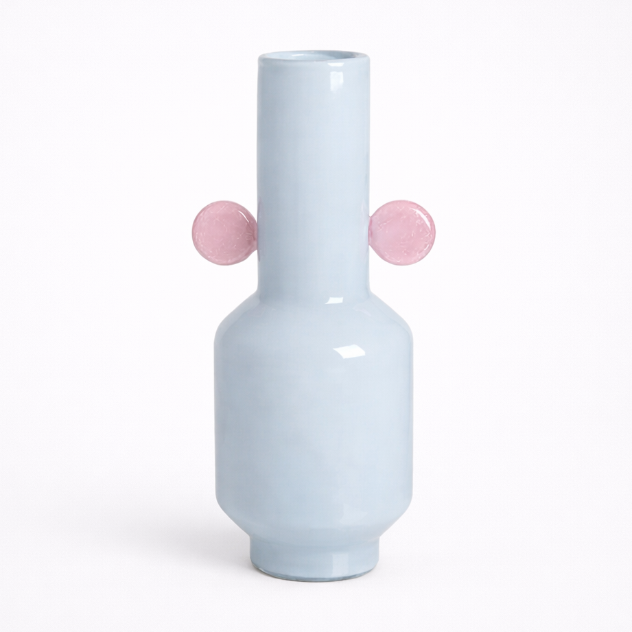 White vase with pink spherical accents on a white background