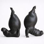 Two bronze sculptures of seals in yoga poses on a white background