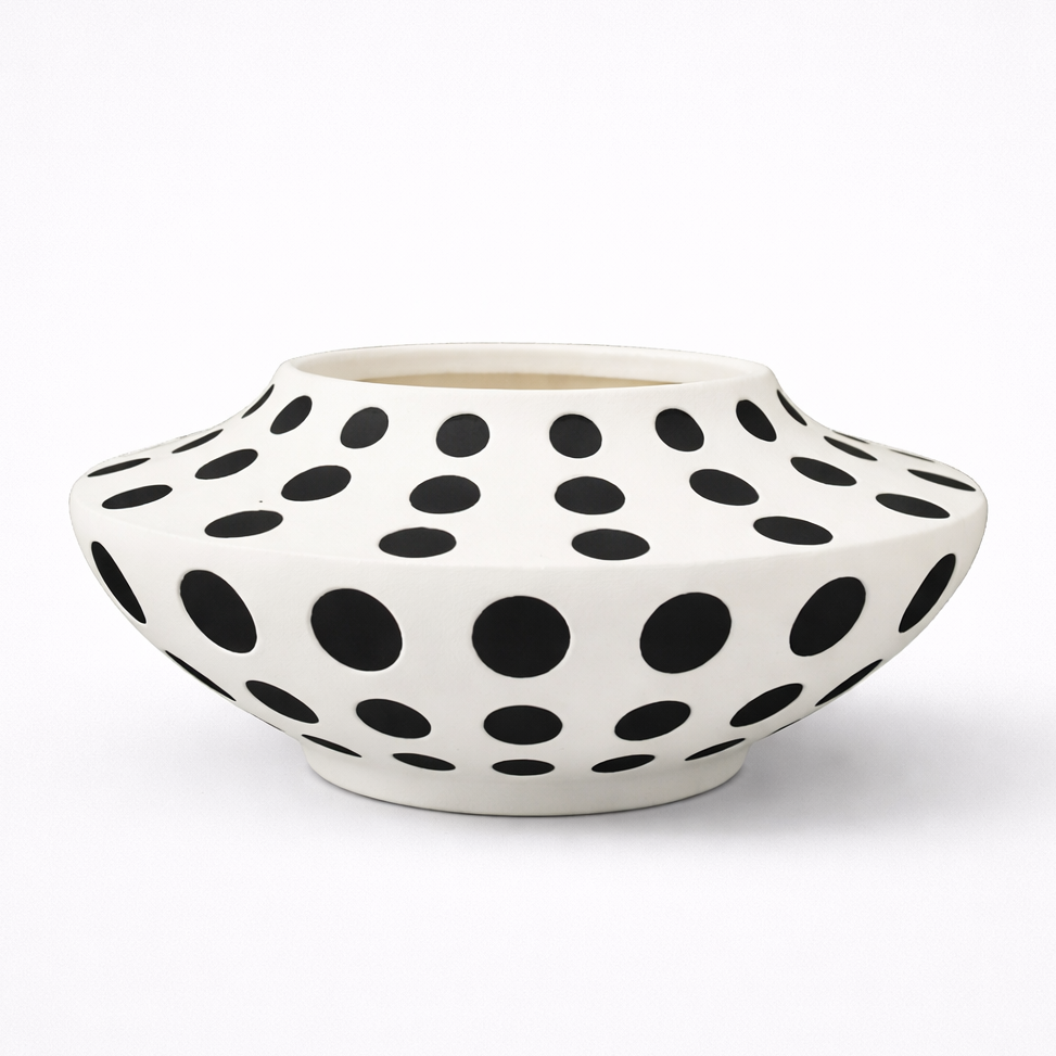 White ceramic vase with black polka dot pattern on a white background