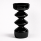 Black ceramic vase with stacked cylindrical design on a white background