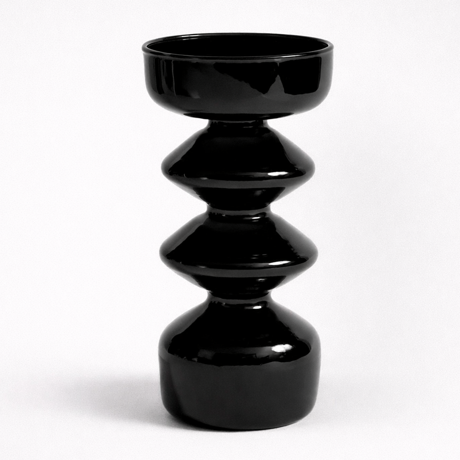 Black ceramic vase with stacked cylindrical design on a white background