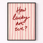 Framed print with 'How lucky are we?' text on a pink and white striped background