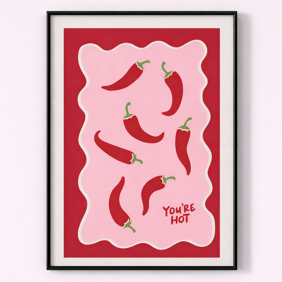 Framed artwork with red peppers and 'You're Hot' text on a pink background