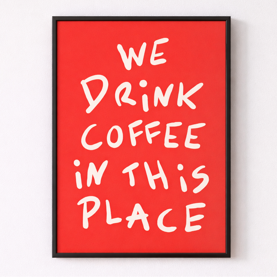 Framed poster with 'We Drink Coffee in This Place' text on a red background