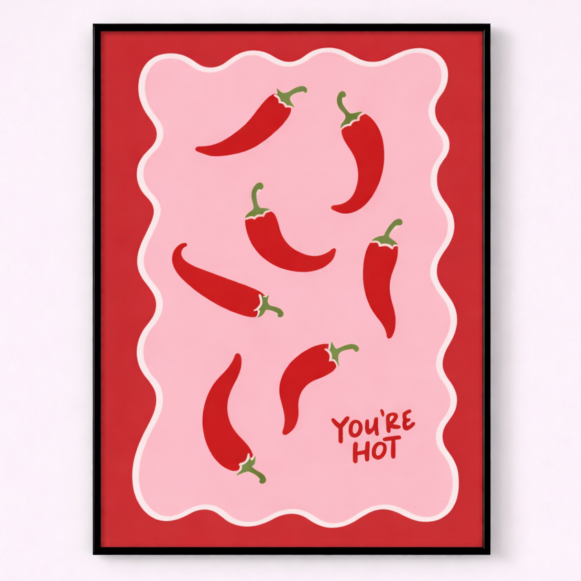 Framed artwork with red peppers and 'You're Hot' text on a pink background