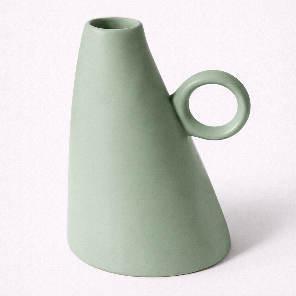 Green vase with a circular handle on a white background