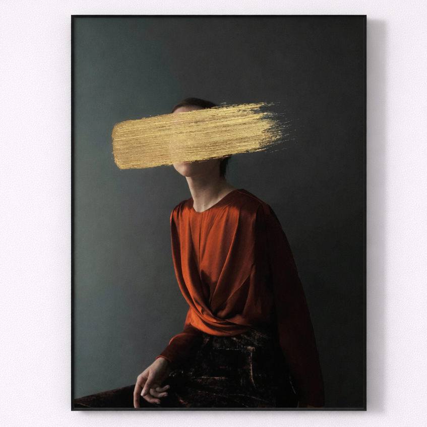 Framed artwork of a person with a gold brushstroke over their face on a dark background