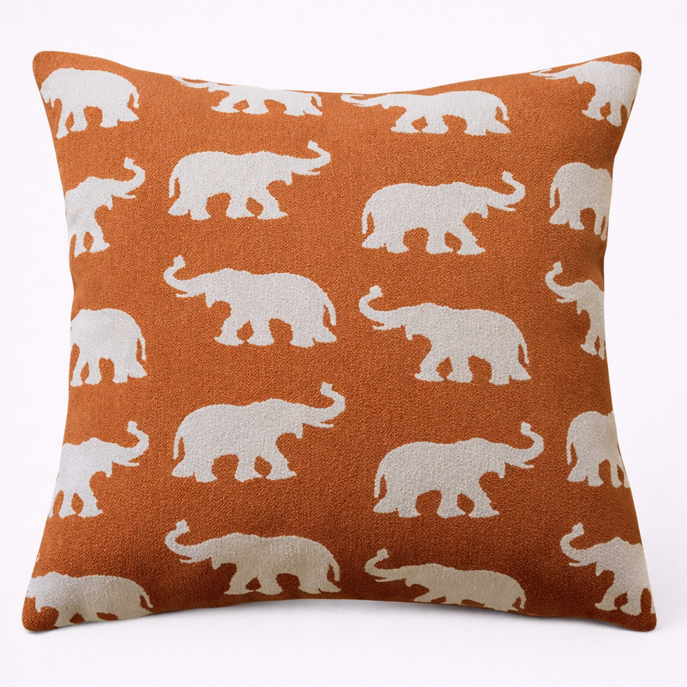 Pillow with white elephant pattern on orange background