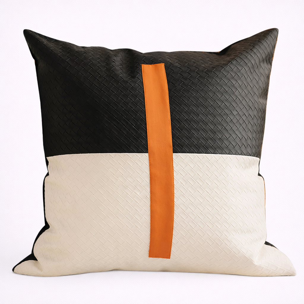 Decorative pillow with black, orange, and beige color block design on a white background