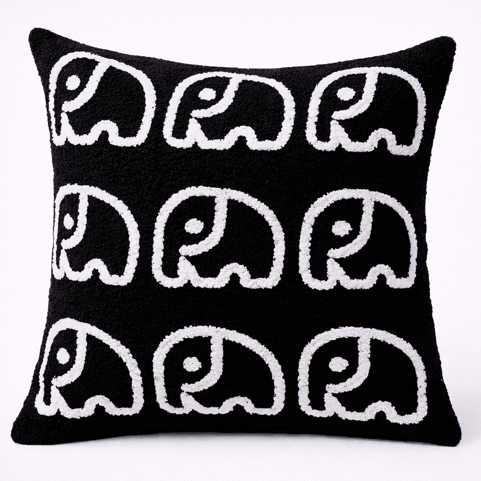 Black pillow with white elephant pattern on a white background