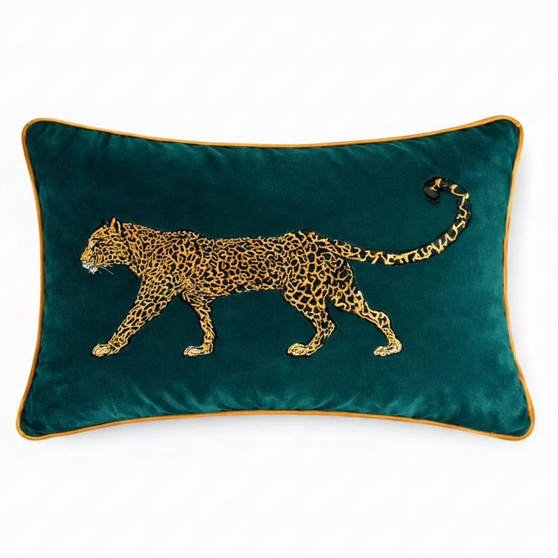 Teal pillow with a gold embroidered leopard design on a white background