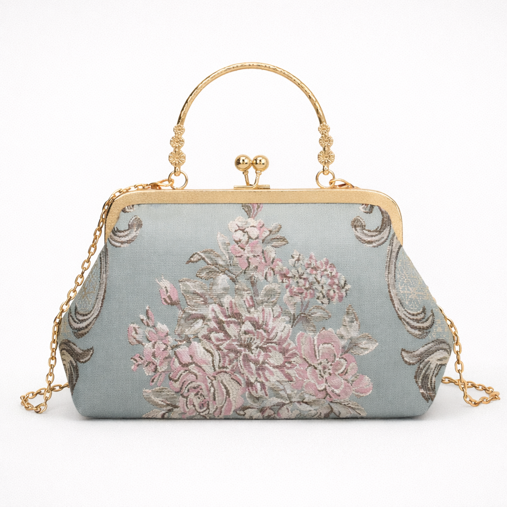 Floral patterned handbag with gold chain and handle on a white background