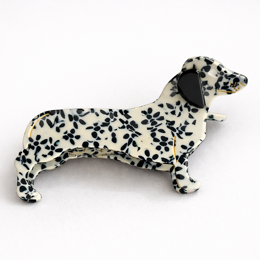 Dog-shaped bottle opener with black and white pattern on a white background