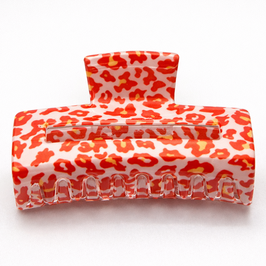 Two red and white leopard print hair clips on a white background