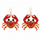 Red crab-shaped earrings with a heart detail on a white background