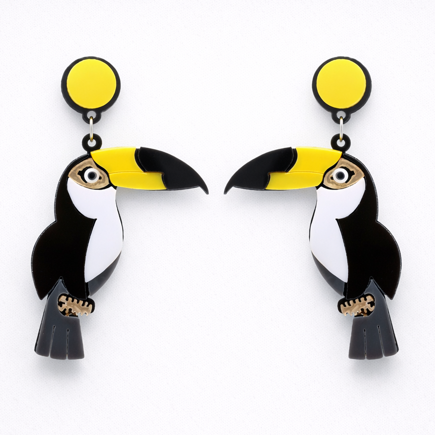 Toucan-shaped earrings with yellow beaks on a white background