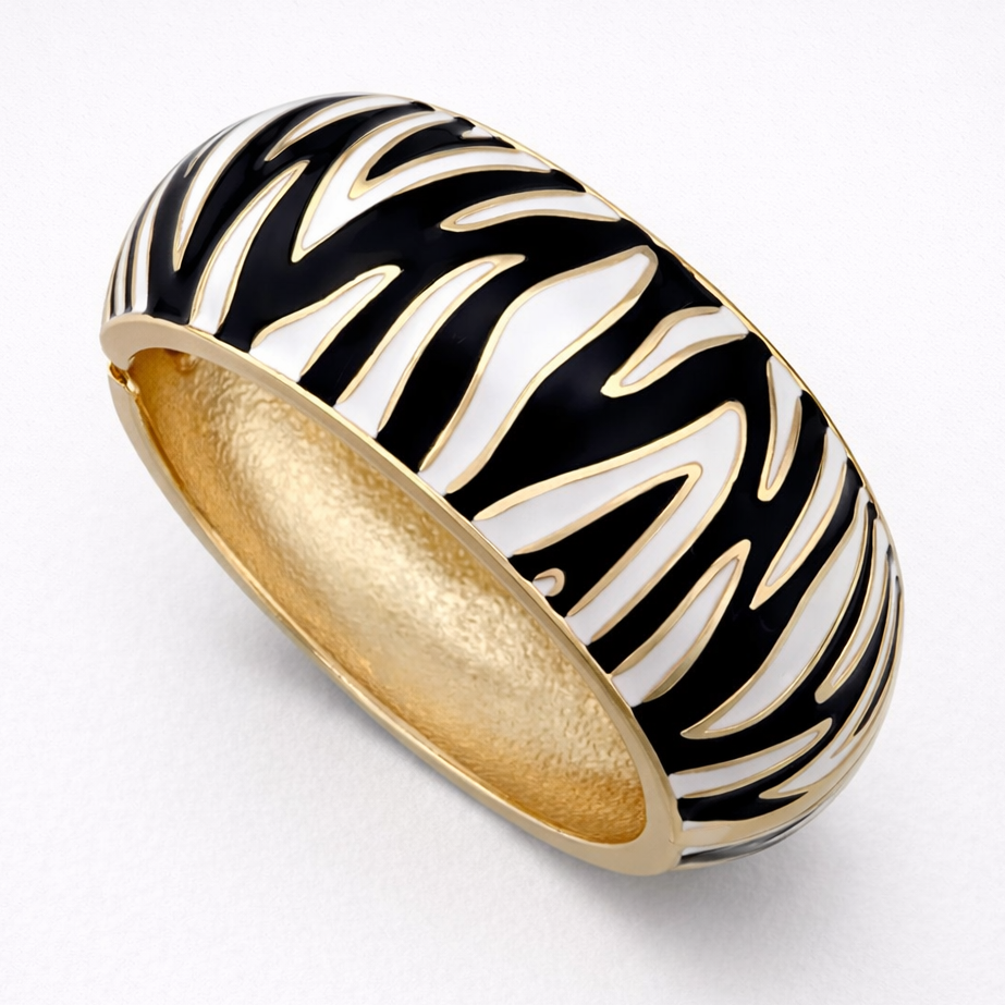 Gold ring with black and white zebra pattern on a light gray background