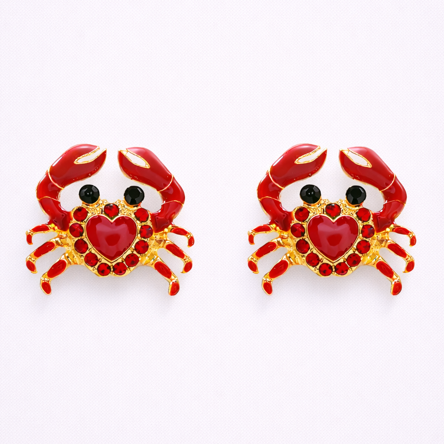 Pair of crab-shaped earrings with red hearts on a white background