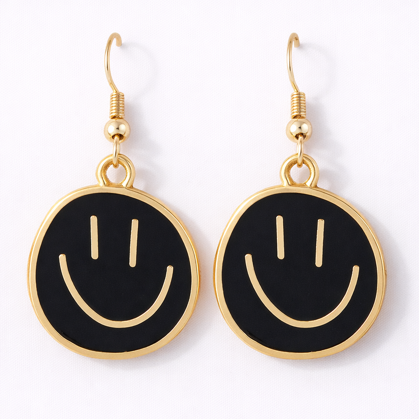 Black smiley face earrings with gold accents on a white background