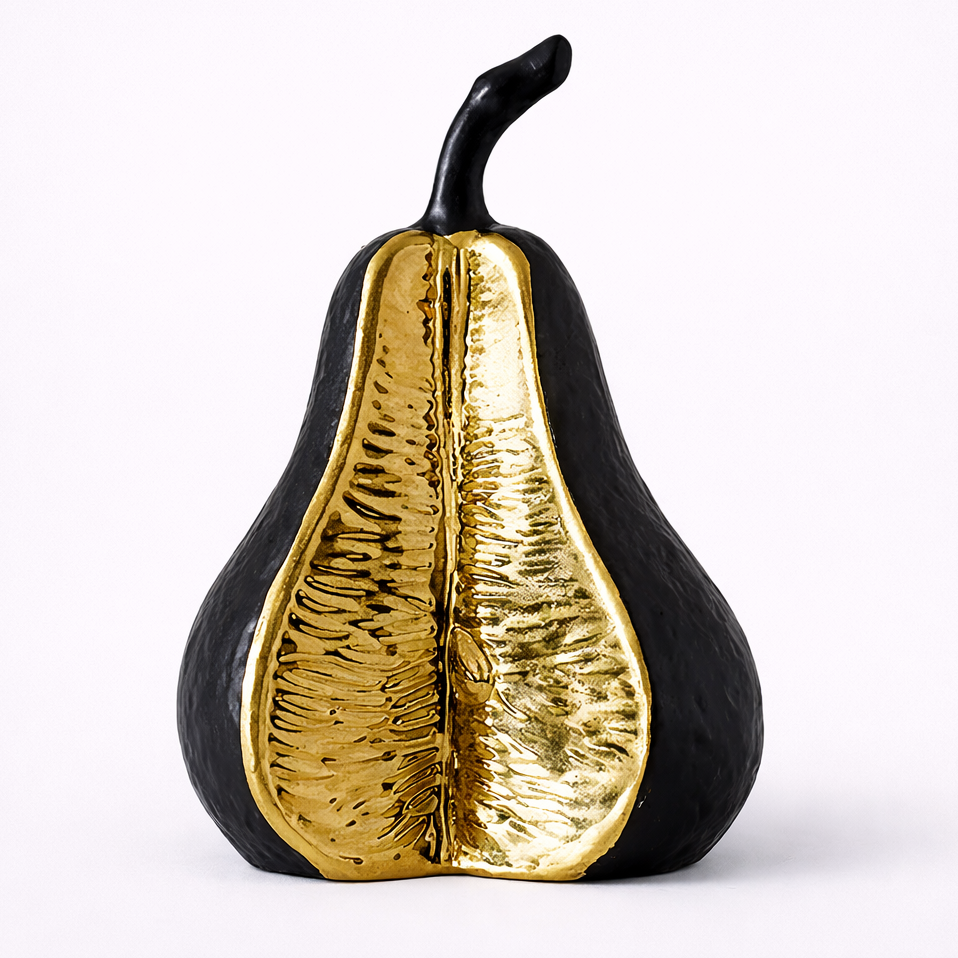 Decorative pear with one side gold and one side black on a white background