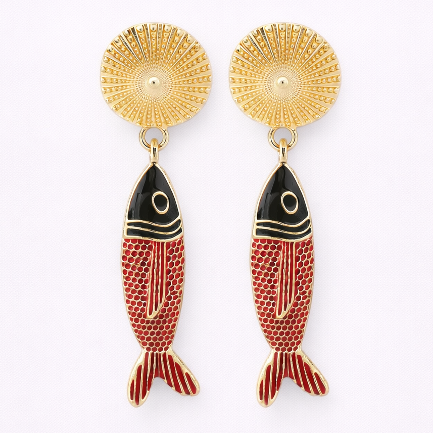 Gold fish-shaped earrings with black and red details on a white background
