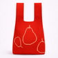 Red reusable shopping bag with pear designs on a white background