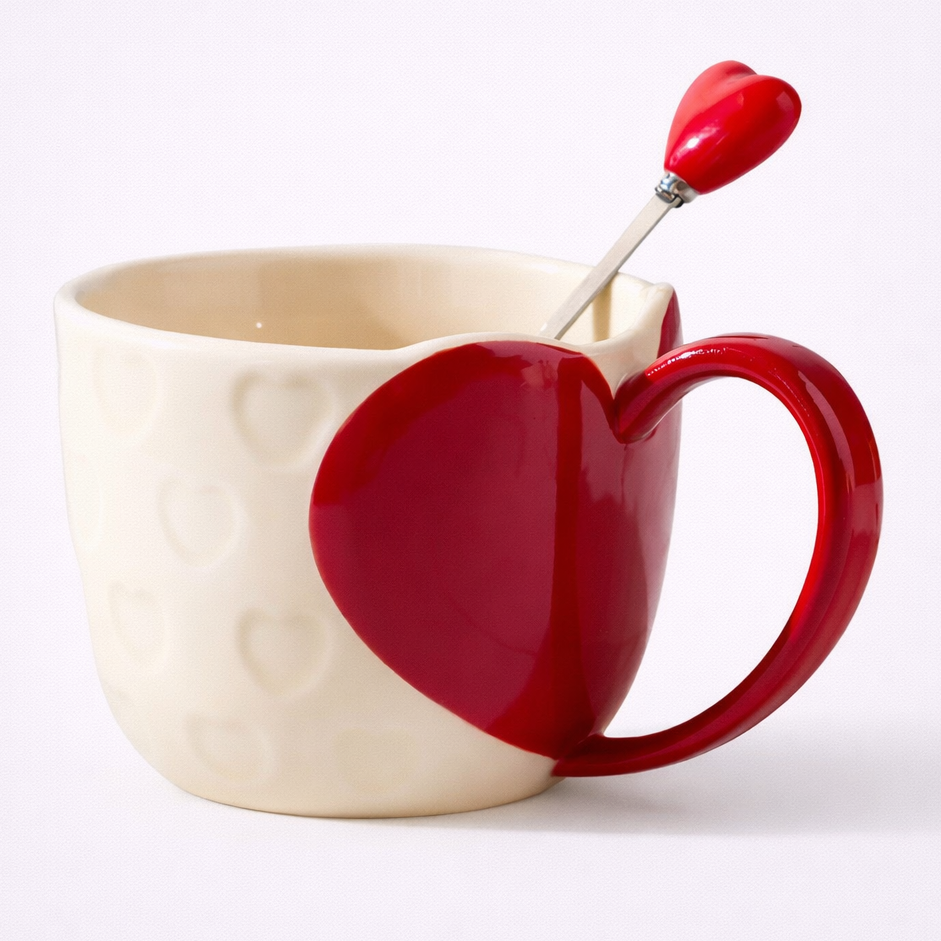 Red heart-shaped mug with a matching spoon on a white background