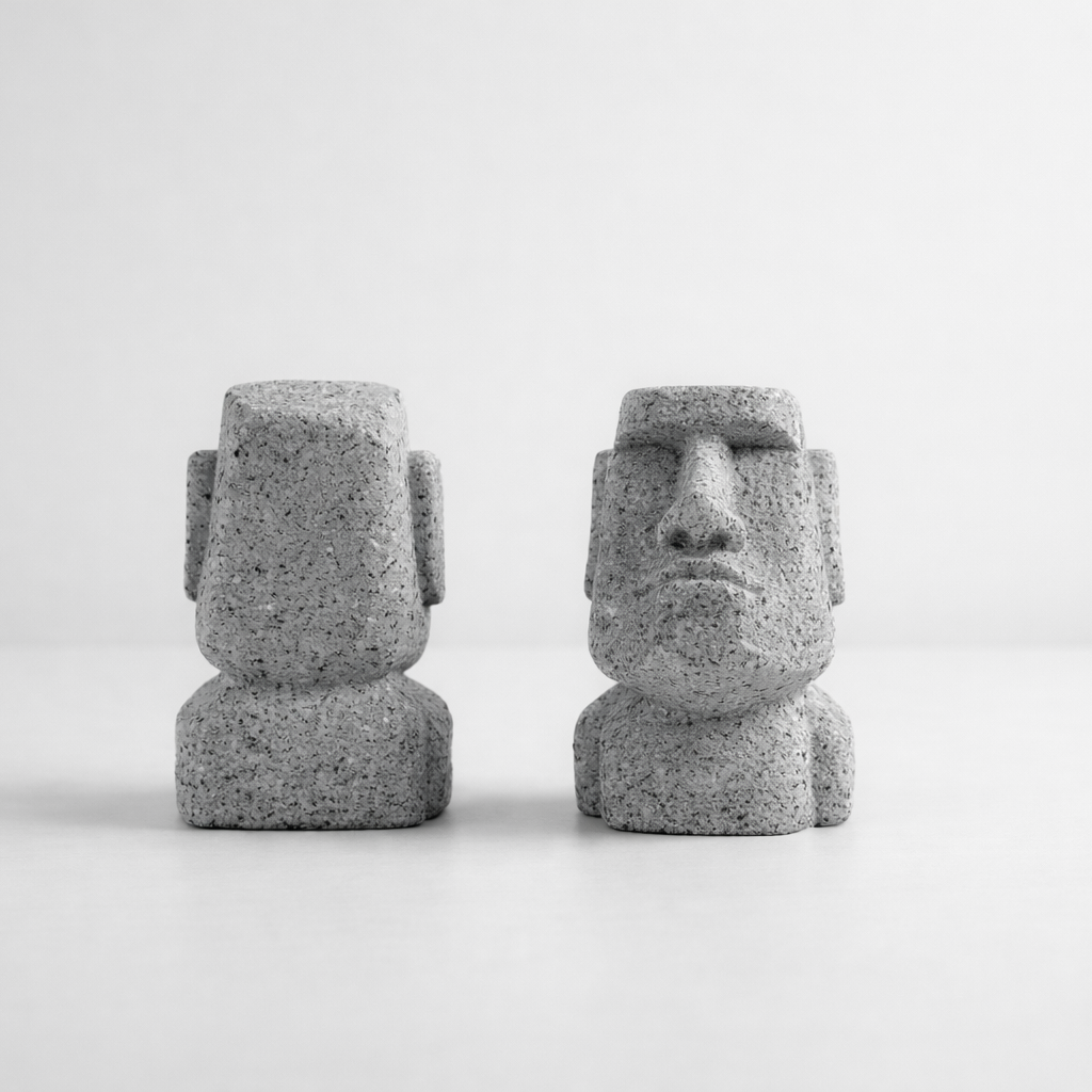 Two stone-like sculptures resembling Moai on a white background