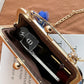 Gold clutch bag with a chain on a brown surface