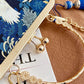 Gold bracelet with decorative elements on a blue floral background