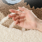 Hand on a textured surface with white and brown colors