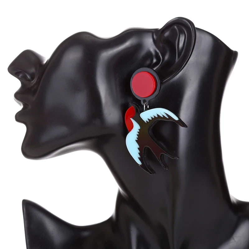 Earrings with red and blue design on a black mannequin ear