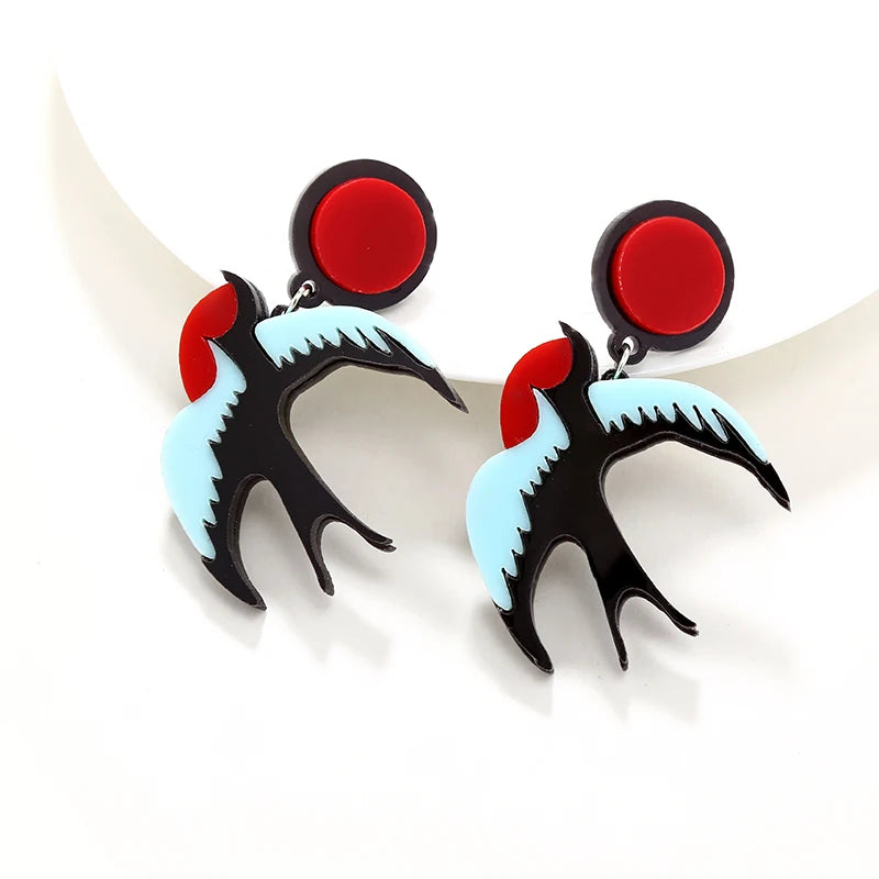 Pair of earrings with red, black, and light blue design on a white background